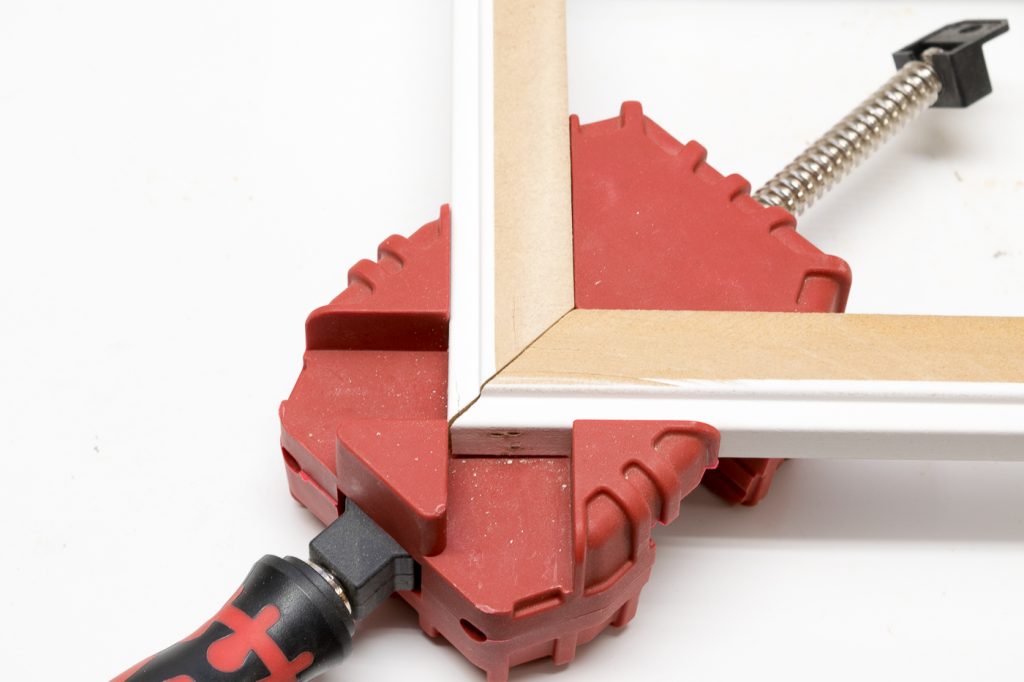 A corner clamp made it easier to hold the miter in place when using the nail gun.