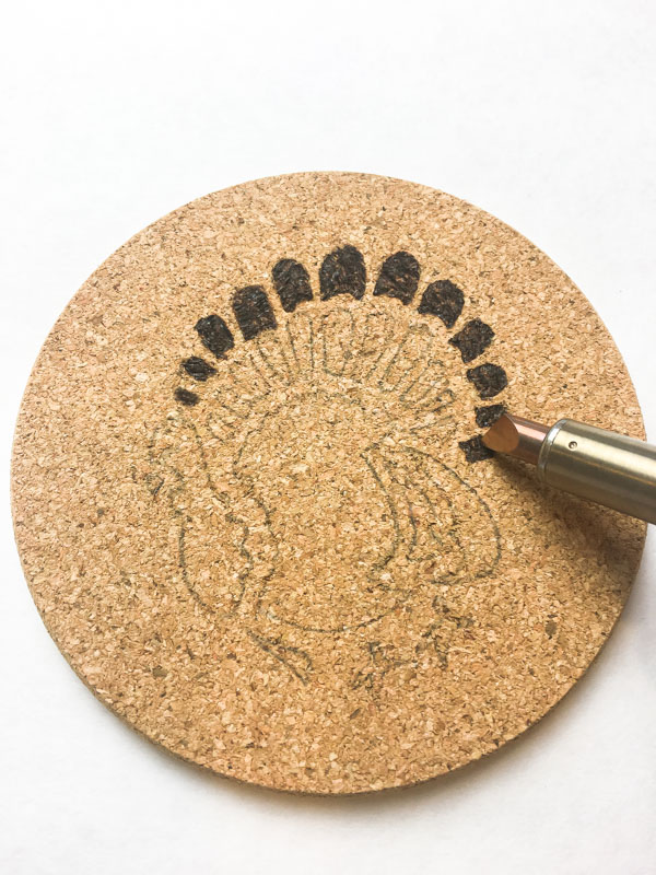 Use the tip of the wood burning tool to fill in small areas on your cork trivet design.
