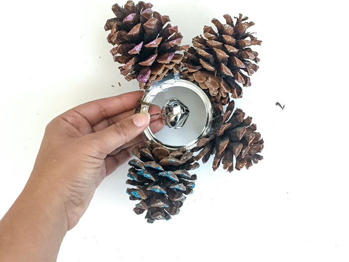 Adding a bell to a pinecone door hanger