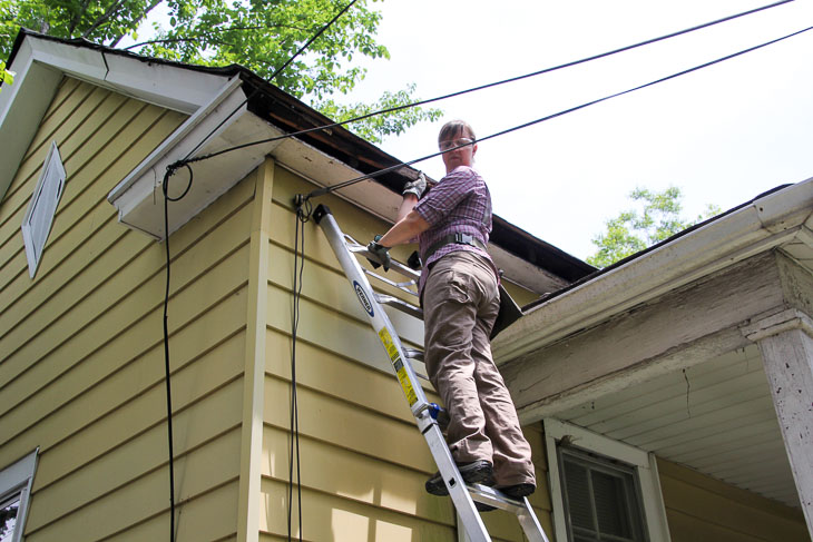 phg woman on ladder looking at low voltage lines