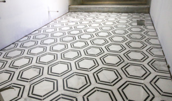 The Builder Depot Carrara Venato Hexagon Nero Strip Marble Mosaic Tile installed on bathroom floor