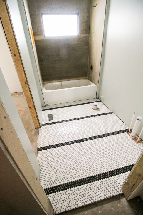 black stripes in small white hex tile field on bathroom floor