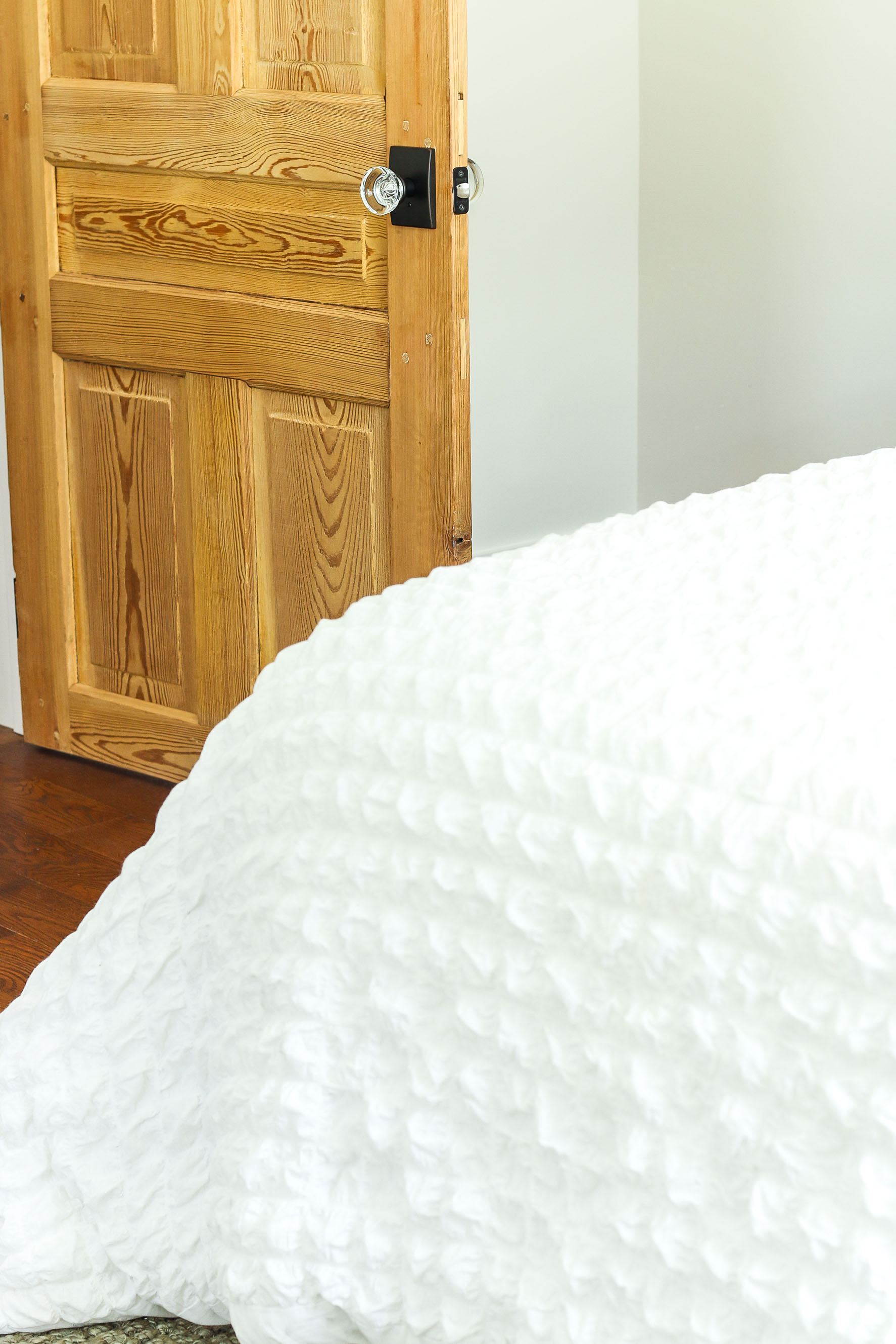 bedroom with 1900 wood door and glass door knob in the background