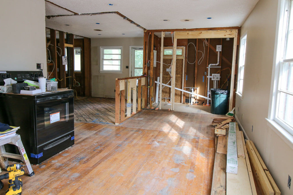 view into living room and kitchen walls down to studs and framing