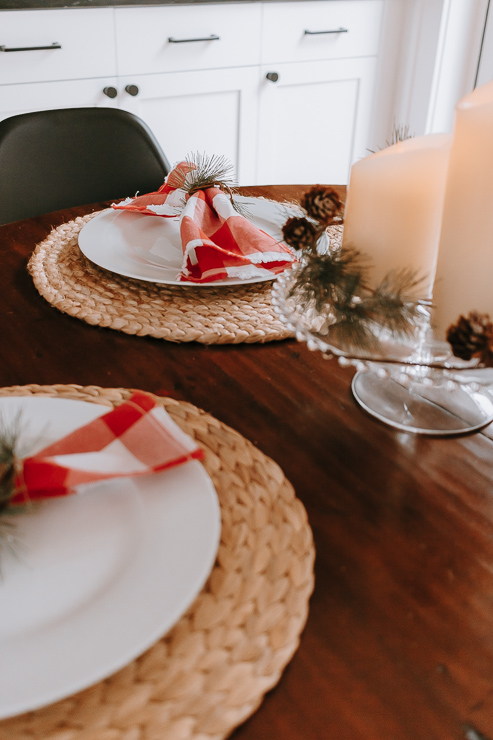 Christmas Table with candles and red napkins and festive napkin rings