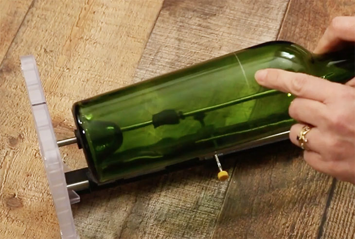 pointing out scored cut line on wine bottle