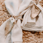 view of napkins tied with jute twine and a clay leaf place card