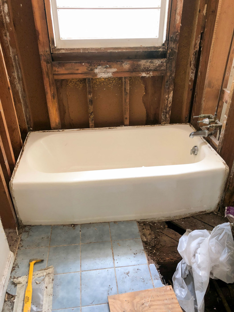 white cast iron tub in gutted bathroom